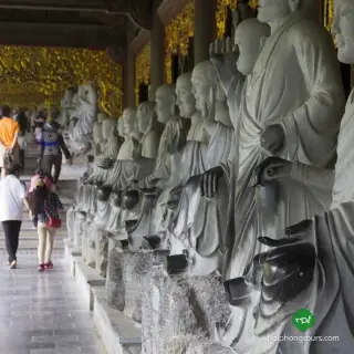 Rows of stone Arhat figures along a covered corridor at Bai Dinh
