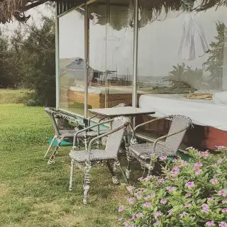 Glass-fronted homestay room with garden seating on Quan Lan Island