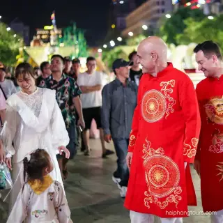 Travelers wearing red Vietnamese ao dai on a Hai Phong evening walk