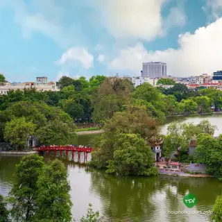 The red The Huc Bridge leading to Ngoc Son Temple island on Hoan Kiem Lake