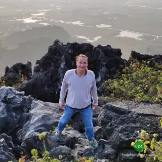 A hiker standing on jagged limestone above the countryside at Elephant Mountain