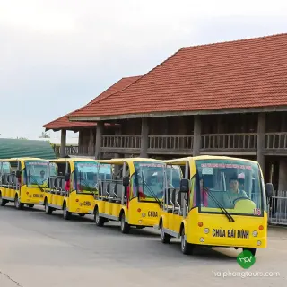 Yellow electric visitor shuttles lined up at Bai Dinh Pagoda